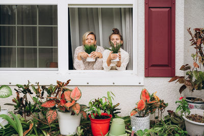 Smiling mother and daughter in frame of window 