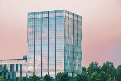 Low angle view of modern glass building against sky