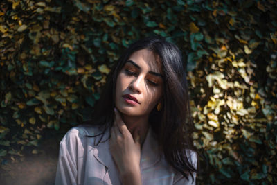 Portrait of a beautiful young woman with autumn leaves