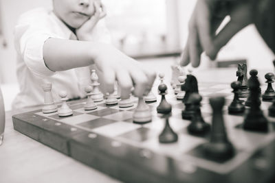 Midsection of boy playing chess