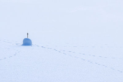 Snow covered field against clear sky