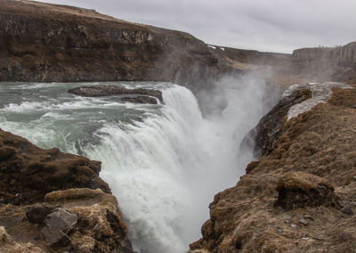 Scenic view of waterfall against sky