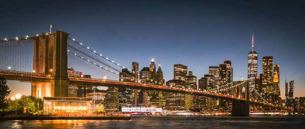 Illuminated bridge over river at night.new york city, united states of america