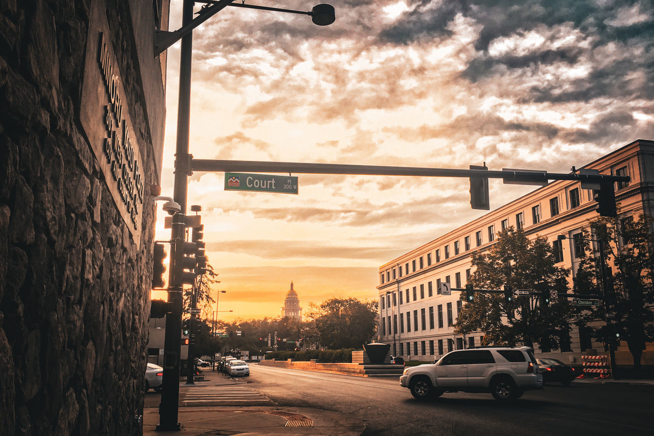 architecture, city, car, sky, transportation, mode of transportation, street, motor vehicle, built structure, building exterior, cloud, evening, road, urban area, sunset, nature, land vehicle, city street, cityscape, building, light, lighting, city life, travel destinations, travel, traffic, no people, vehicle, night, darkness, infrastructure, outdoors, street light, sign, dusk