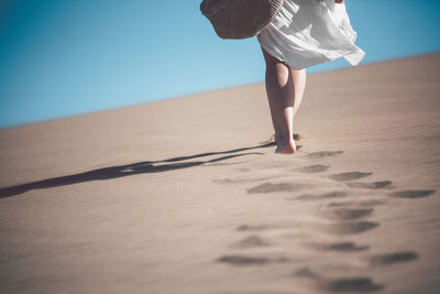 Low section of woman walking on beach