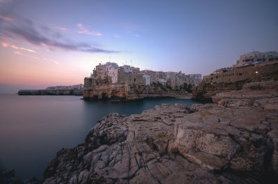 Scenic view of sea by buildings against sky