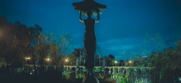 Illuminated light by sea against sky at night