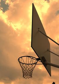 Low angle view of basketball hoop against sky during sunset