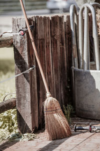 Broom stand in backyard next to paddock on fence after clean up the garden and maintain the house 