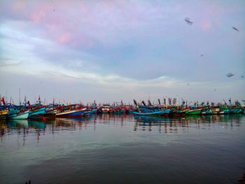 Boats moored in sea against sky