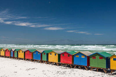 Multi colored beach umbrellas by sea against sky