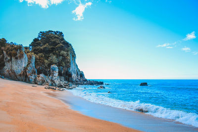 Scenic view of beach against blue sky