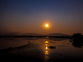 Scenic view of lake against sky during sunset