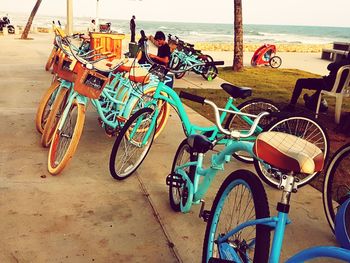 Bicycles by sea against sky