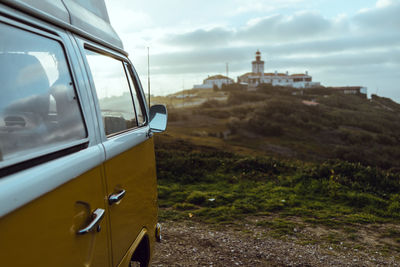 Close-up of car on landscape against sky