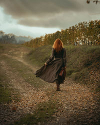 Redhead woman walking in the countryside