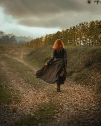 Rear view of woman standing on field