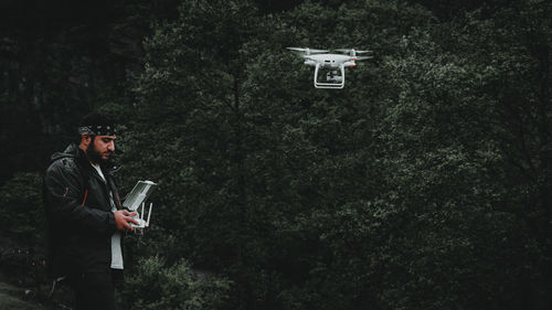 Side view of man using mobile phone in forest