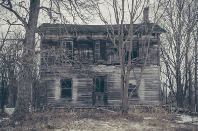Abandoned built structure against bare trees