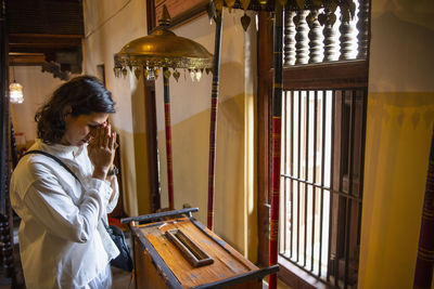 Buddhist worshiper donating at the temple of the holy tooth relic