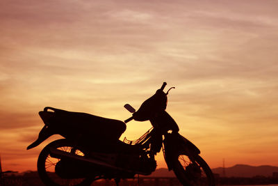 Statue of silhouette horse riding against sky