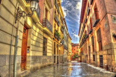 Walkway amidst city against sky