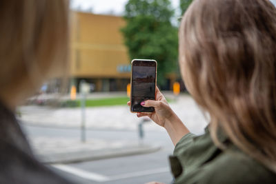 Portrait of man photographing mobile phone