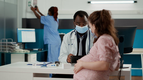 Doctor examining female patient at clinic