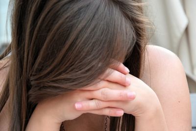 Depressed woman with head in hands