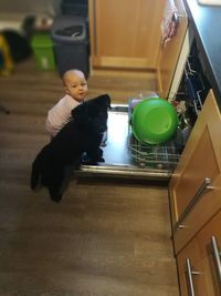 High angle view of child looking at camera at home