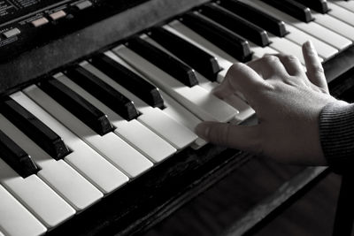 Cropped hand of person playing piano