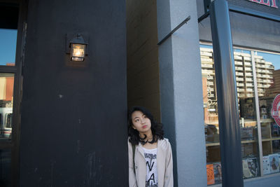 Portrait of smiling young woman standing in city