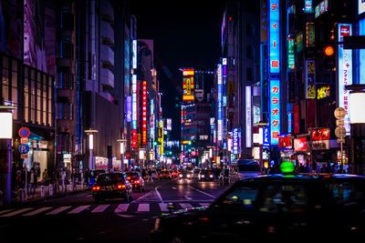 Cars moving on road in illuminated city at night