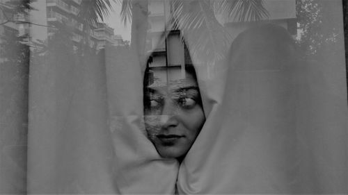 Close-up of woman wrapped in curtain