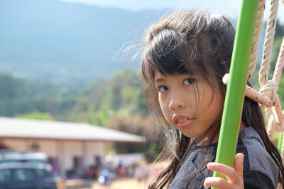 Portrait of cute girl by outdoor play equipment