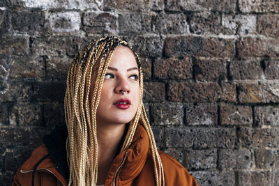 Portrait of beautiful woman against wall