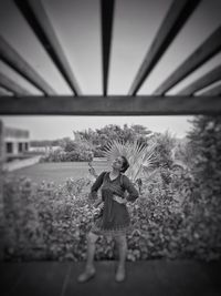 Girl with flowers on field against sky
