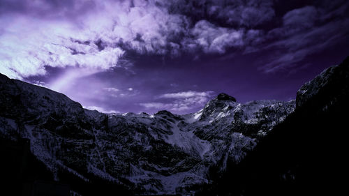 Scenic view of snowcapped mountains against sky at night
