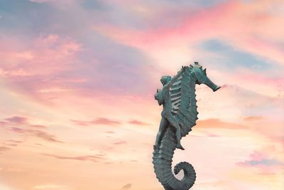 Low angle view of silhouette statue against sky during sunset