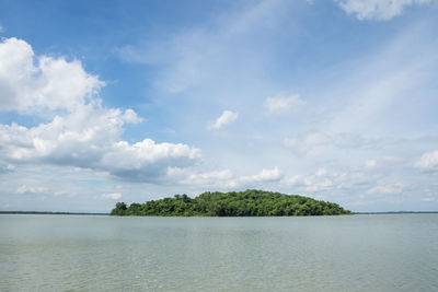 Scenic view of island against cloudy sky