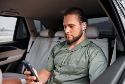 Portrait of young man sitting in car