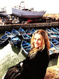 Portrait of smiling young woman standing on boat