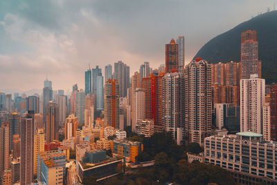 Modern buildings in city against cloudy sky