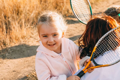 Portrait of smiling girl sitting on moms hands with rocket 