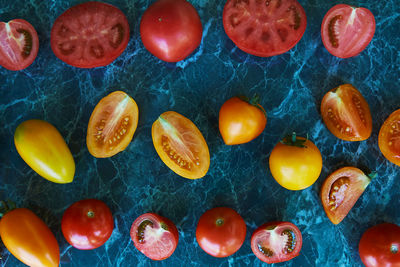 Colorful food - red, orange and yellow tomatoes on green marble background. natural, organic food