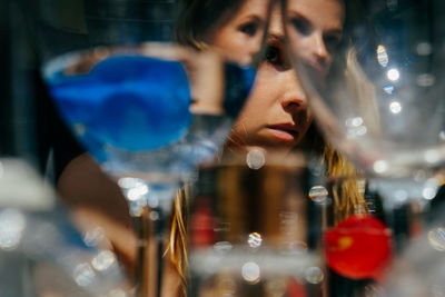 Portrait of woman with reflection in glass at store