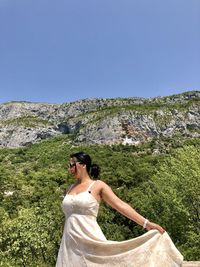 Woman standing on mountain against clear sky and monastery 