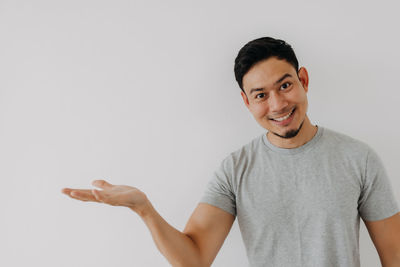 Portrait of young man standing against white background