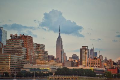 Buildings in city against cloudy sky