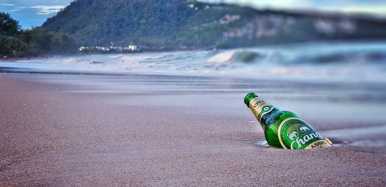 CLOSE-UP OF BOTTLE ON SAND